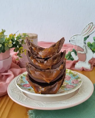 Pilha de ovos de chocolate servida em prato de porcelana, foto sem edição